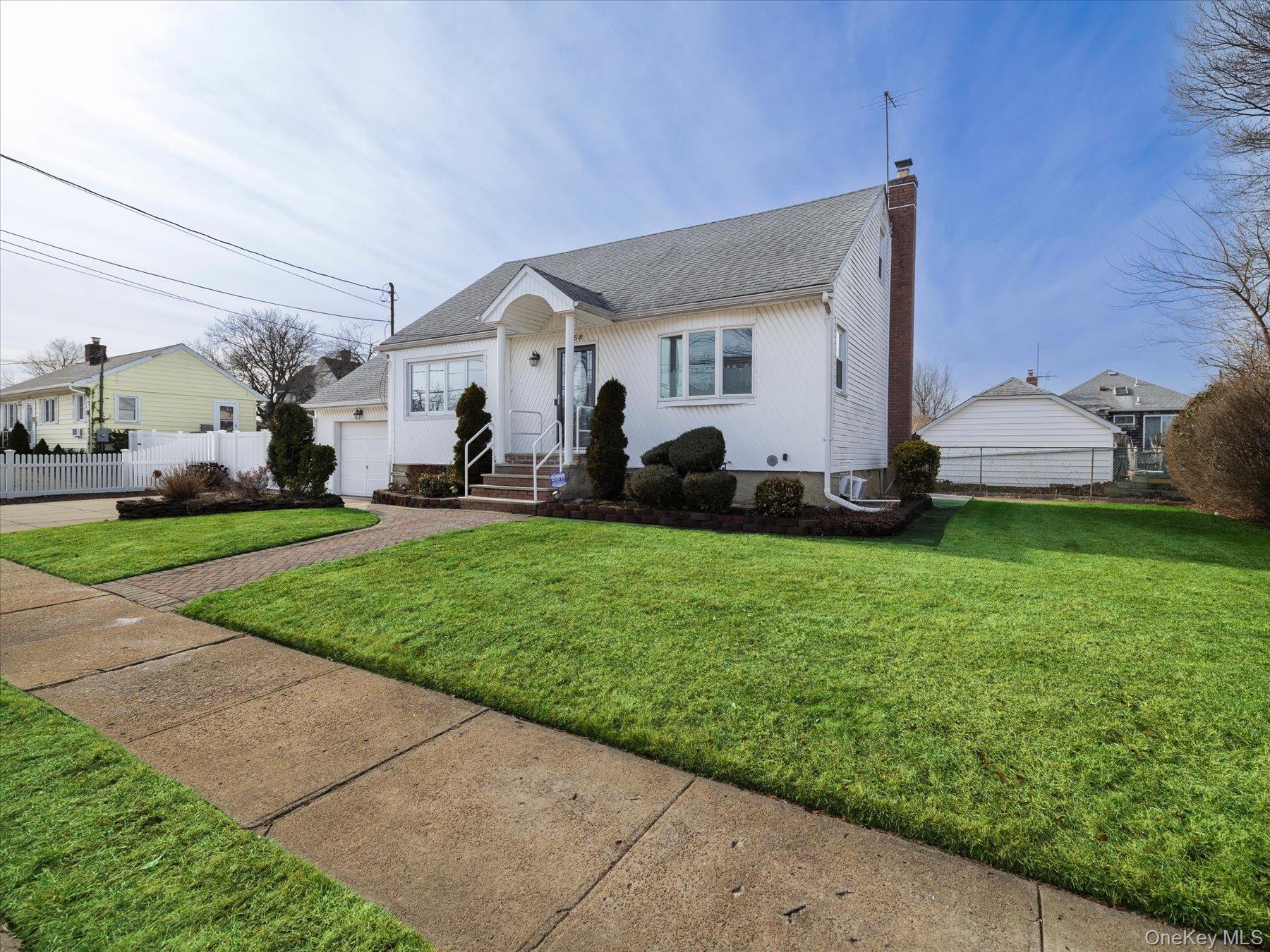 158 Roosevelt Avenue Freeport, NY 11520 - Photo 16 of 30 a front view of a house with a yard and garage