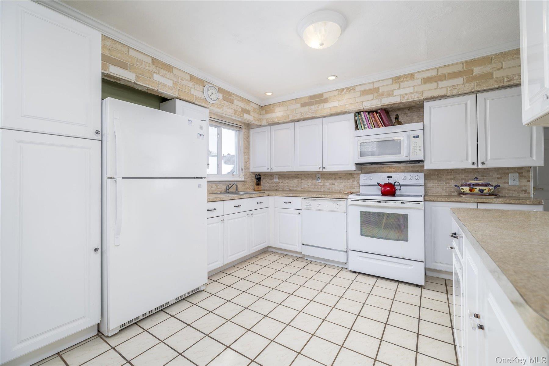 158 Roosevelt Avenue Freeport, NY 11520 - Photo 7 of 30 a kitchen with white cabinets and white appliances