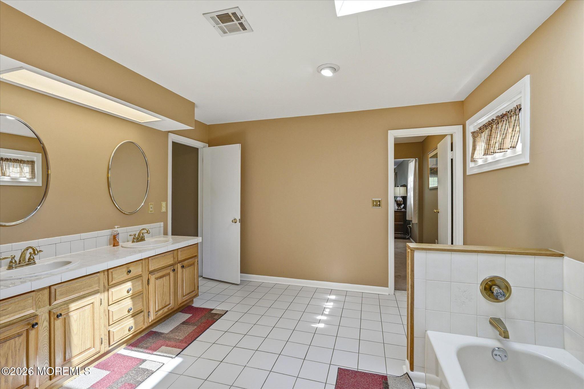 22 Ethan Allen Road Freehold, NJ 07728 - Photo 30 of 31 a bathroom with a double vanity sink mirror and bathtub