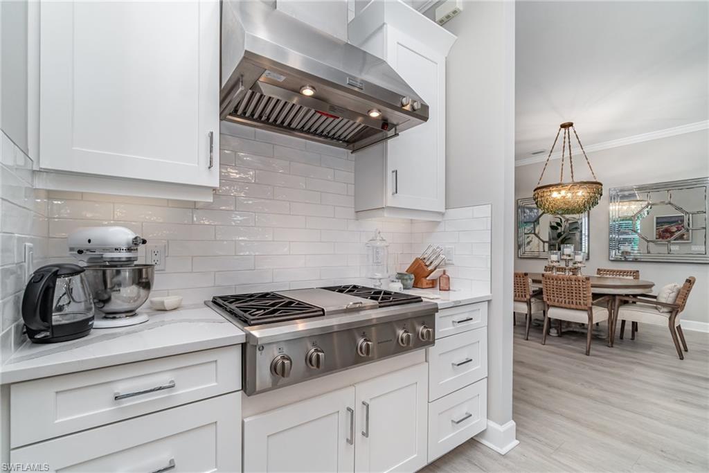 9536 Montelanico Loop Naples, FL 34119 - Photo 11 of 24 a kitchen with a stove and cabinets