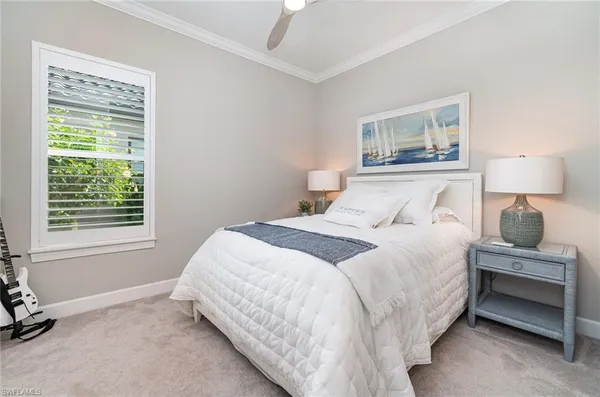 a bedroom with a bed and a lamp on dresser