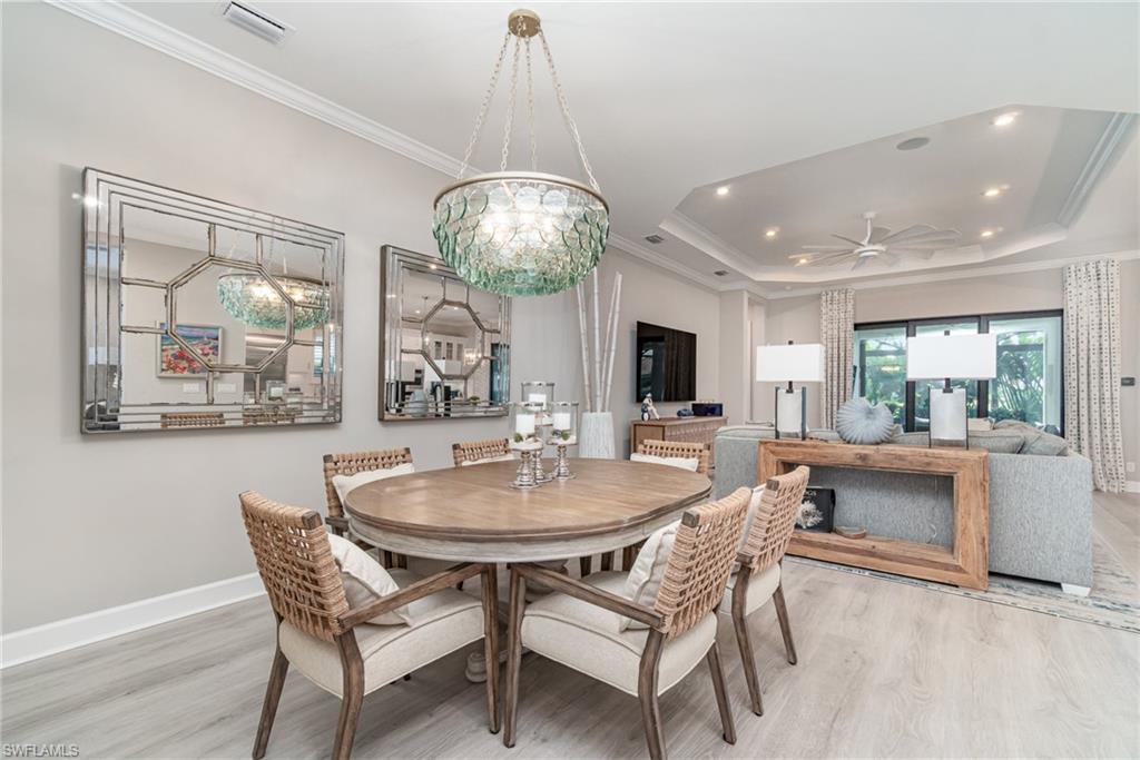 9536 Montelanico Loop Naples, FL 34119 - Photo 8 of 24 a view of a dining room with furniture wooden floor and chandelier