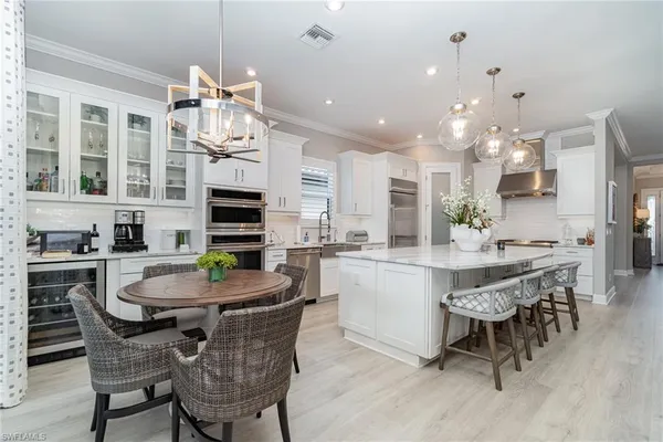 a kitchen with a dining table chairs and cabinets