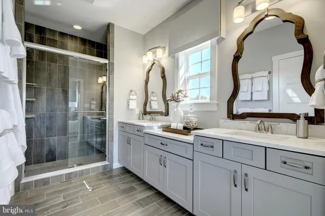 a bathroom with a double vanity sink mirror and shower