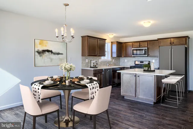 a kitchen with a dining table chairs a sink and cabinets