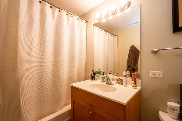 a bathroom with a sink a mirror and a shower curtain