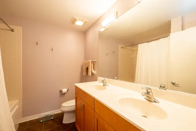 a bathroom with a sink vanity mirror and toilet