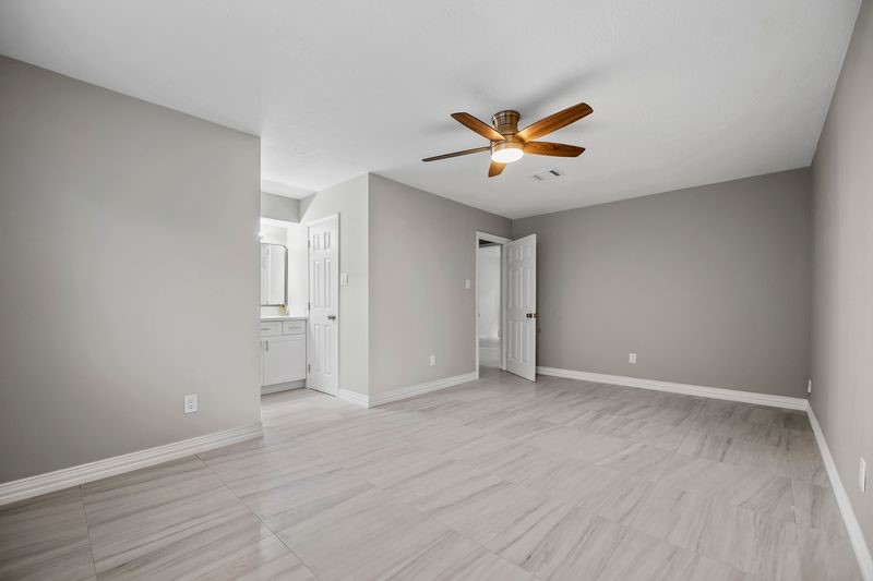 16519 Gaeldom Drive Houston, TX 77084 - Photo 15 of 28 an empty room with wooden floor and ceiling fan