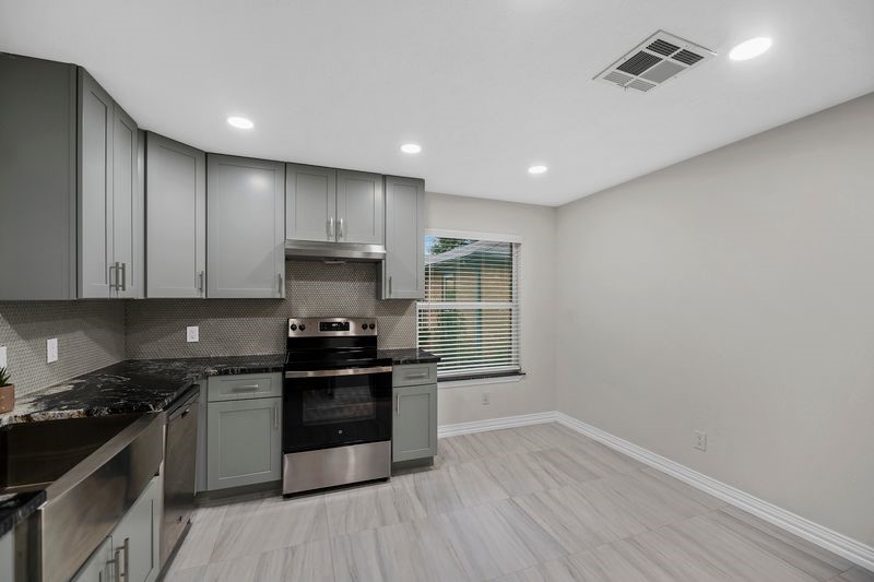 16519 Gaeldom Drive Houston, TX 77084 - Photo 10 of 28 a kitchen with granite countertop a stove and a sink