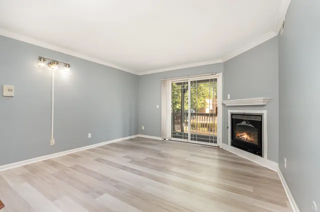 a view of an empty room with a window and fireplace