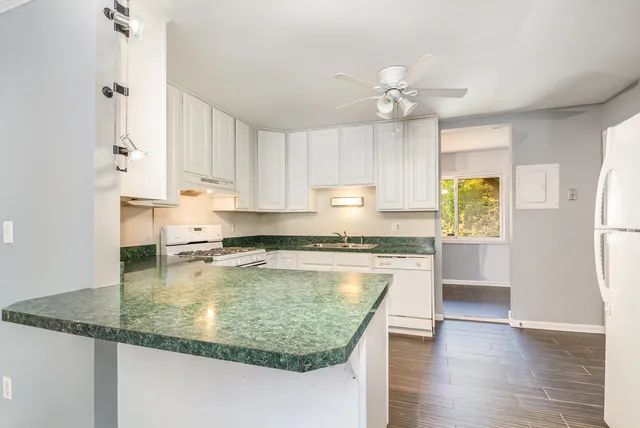 a kitchen with kitchen island granite countertop a sink appliances cabinets and counter space