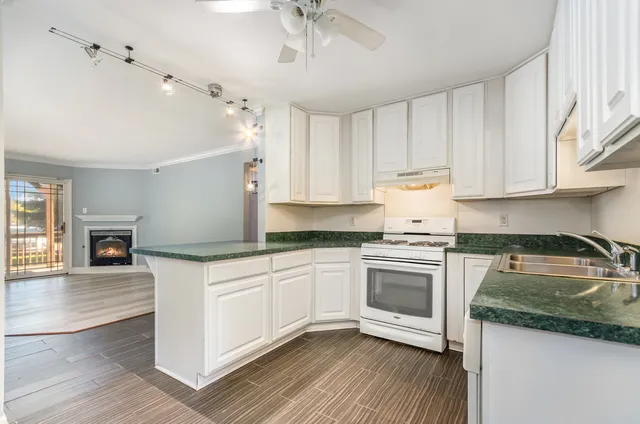 a kitchen with granite countertop white cabinets and white appliances