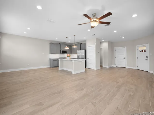 a view of a kitchen with a stove cabinets wooden floor and a ceiling fan