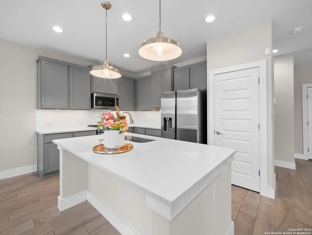 a kitchen with a refrigerator a sink and chairs