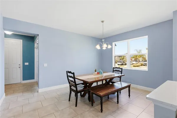 a kitchen with stainless steel appliances a table chairs microwave and refrigerator