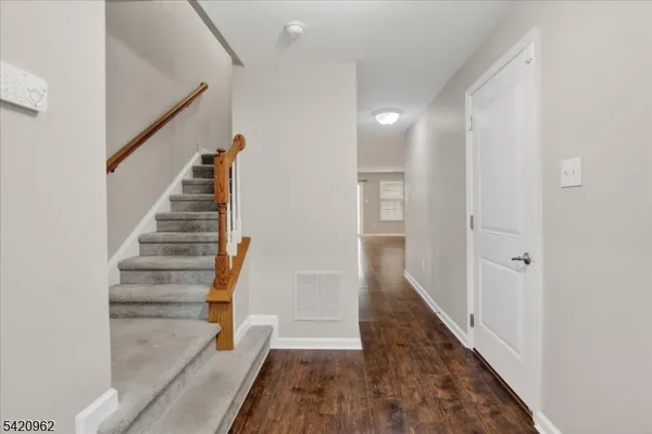 a view of empty room with wooden floor and fireplace