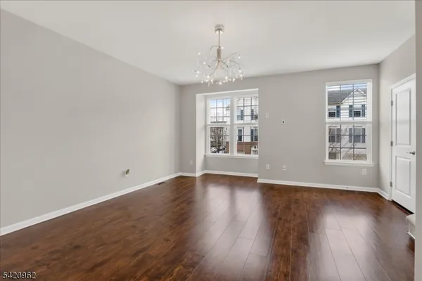 a view of a room with wooden floor staircase and a kitchen
