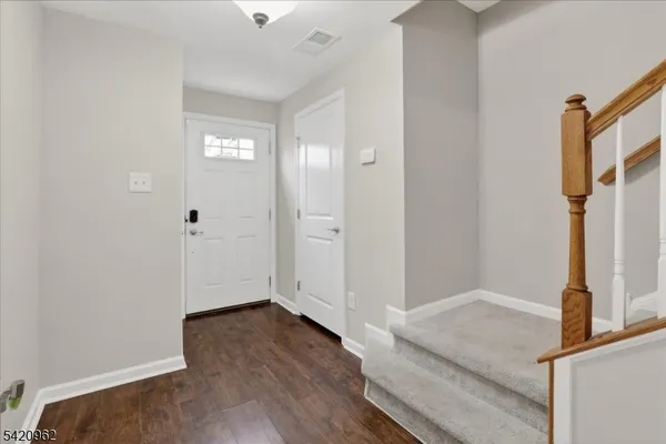 a view of entryway with wooden floor and stairs