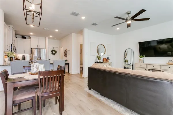 a living room with furniture a flat screen tv and kitchen view