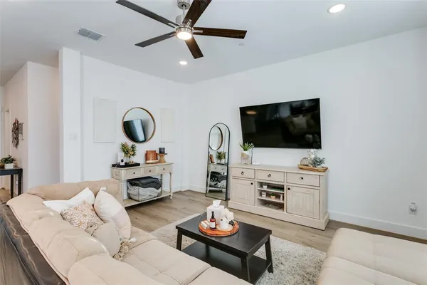 a living room with furniture and a wooden floor