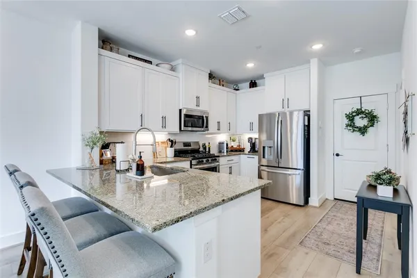 a kitchen with granite countertop a stove top oven sink and cabinets