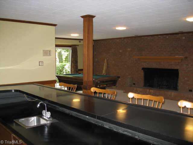 3320 North Rockingham Road Greensboro, NC 27407 - Photo 7 of 9 Other. Freshly painted basement with fireplace and wet bar. Opens to cozy patio cradled by custom brick landscaping.