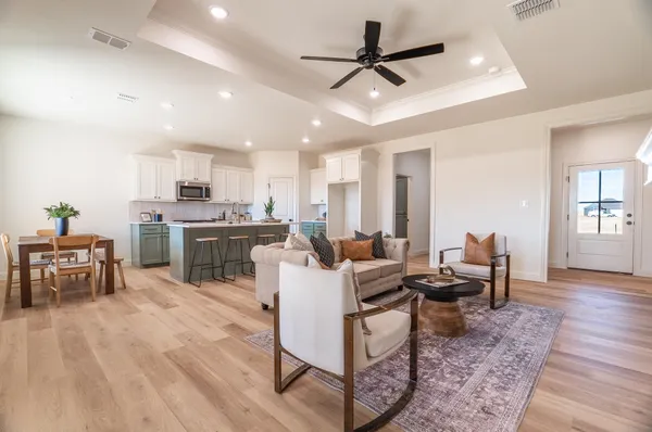 a living room with lots of furniture and kitchen view