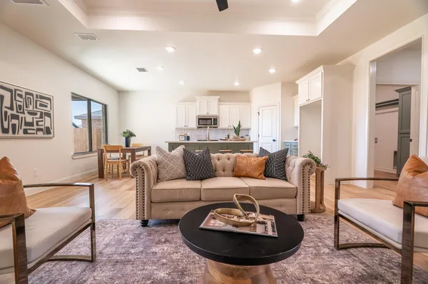 a living room with furniture a rug and kitchen view