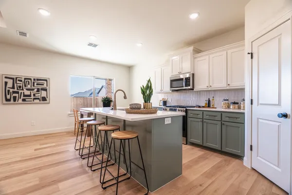 a kitchen with a sink cabinets and wooden floor