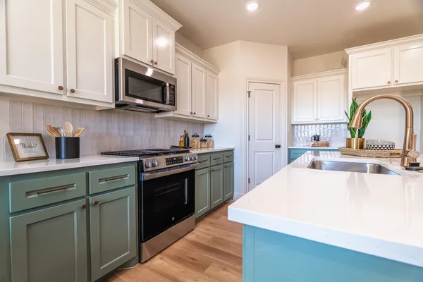 a kitchen with stainless steel appliances granite countertop a sink and dishwasher a stove top oven with wooden floor