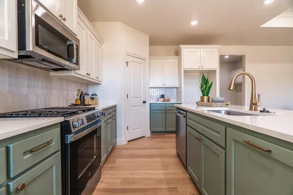 a kitchen with stainless steel appliances a stove sink and cabinets