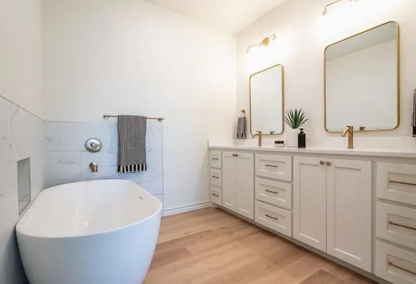 a bathroom with a white tub sink and mirror