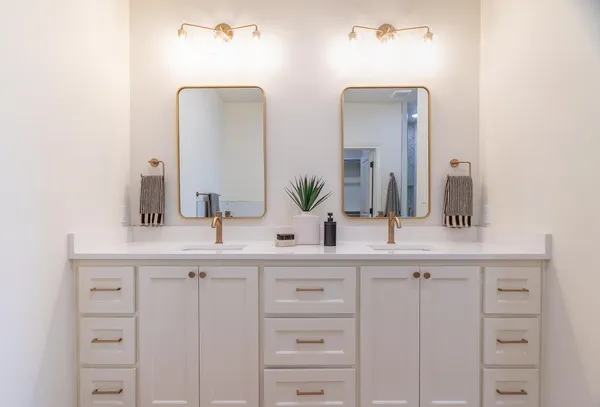 a bathroom with double vanity sinks and a mirror