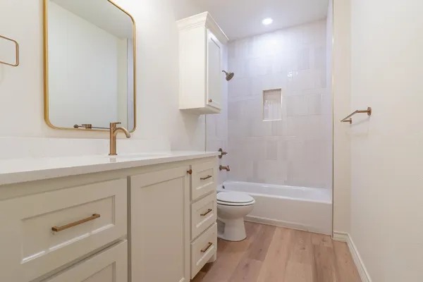 a bathroom with a sink a toilet and shower