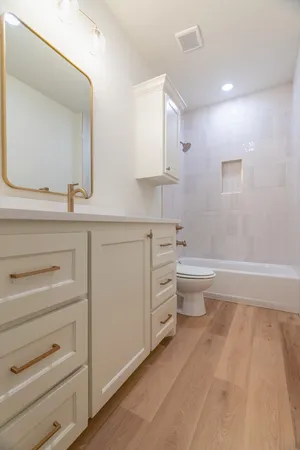 a bathroom with a sink a toilet and a mirror