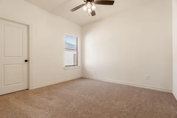 an empty room with a chandelier fan