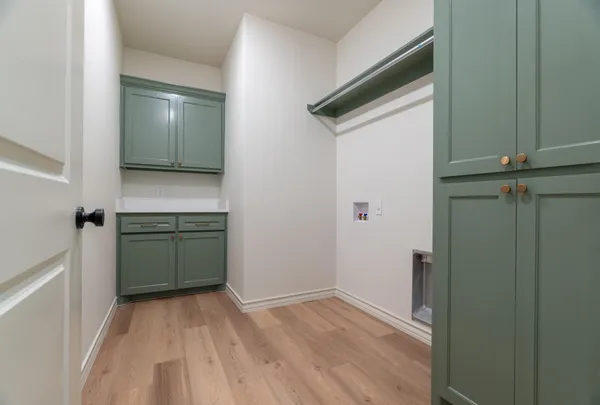 a view of a utility room with closet and wooden floor