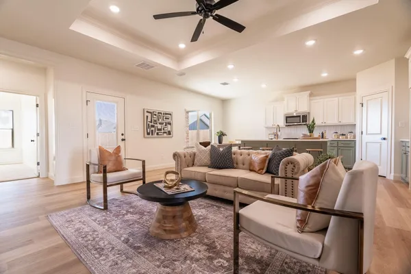 a living room with lots of furniture and view of kitchen