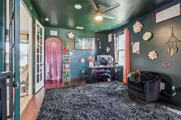 a living room with stainless steel appliances furniture a flat screen tv and a window