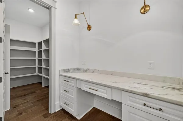a bathroom with a granite countertop toilet and sink