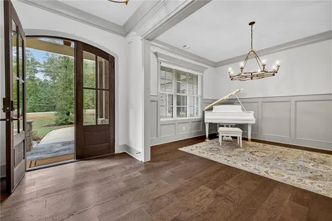 a open kitchen with stainless steel appliances granite countertop a refrigerator oven a sink dishwasher and white cabinets with wooden floor