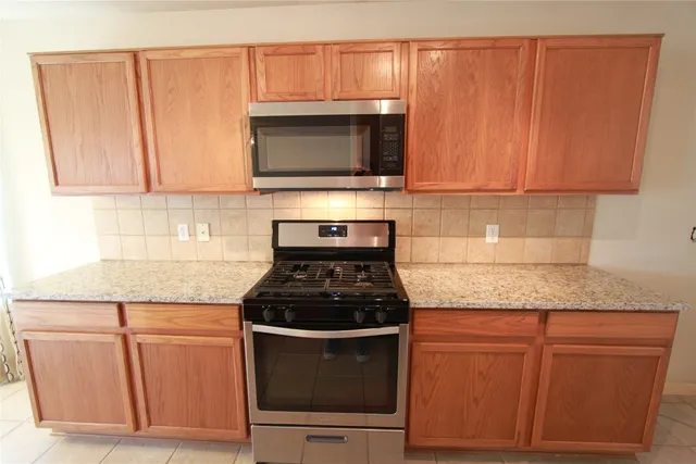 a kitchen with granite countertop wood cabinets and stainless steel appliances