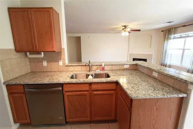 a kitchen with stainless steel appliances granite countertop wooden cabinets a sink and dishwasher