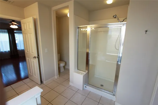 a bathroom with a glass door shower a sink and a toilet