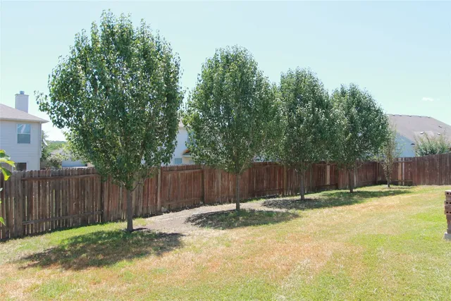 a view of a backyard with wooden fence