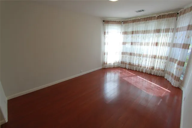 a view of a room with wooden floor and a window