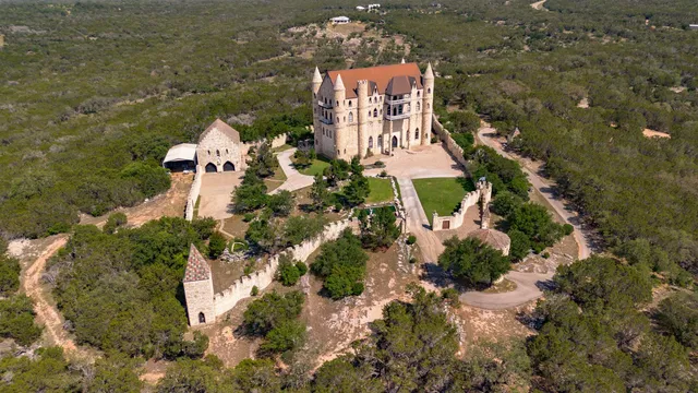 an aerial view of a house with a yard and lake view