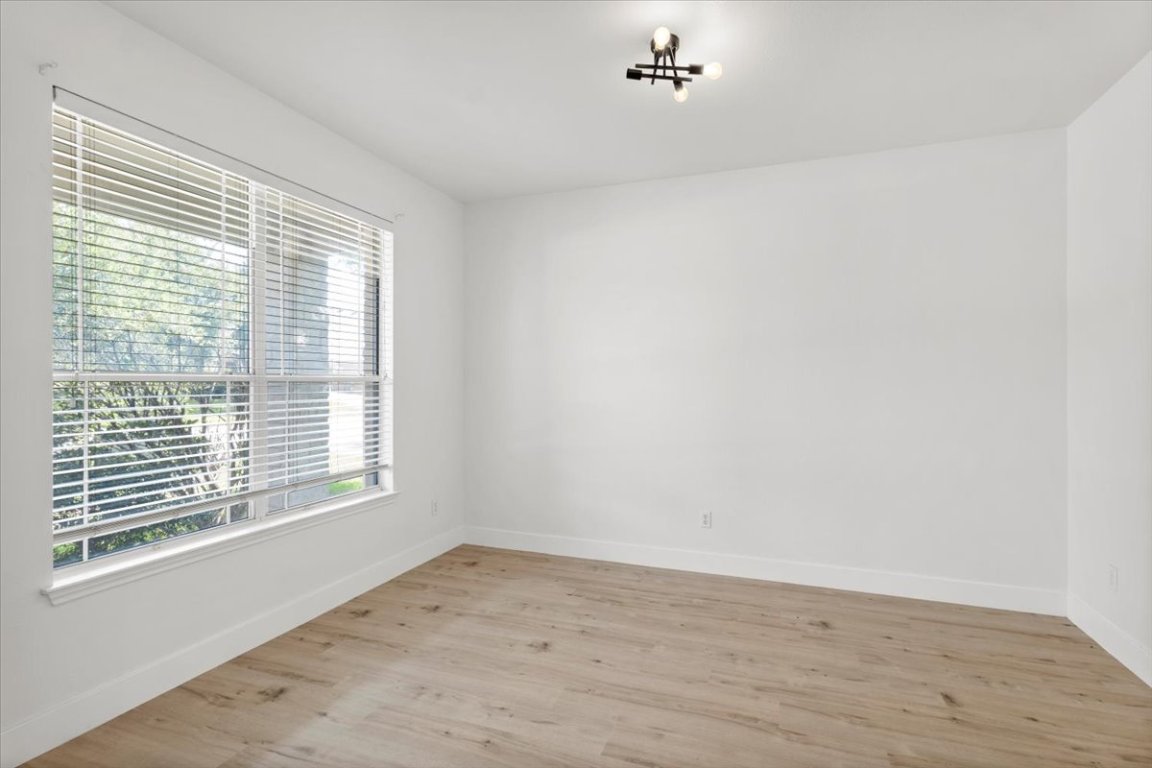 3702 Tall Cedars Road Cedar Park, TX 78613 - Photo 13 of 34 a view of an empty room with wooden floor and a window