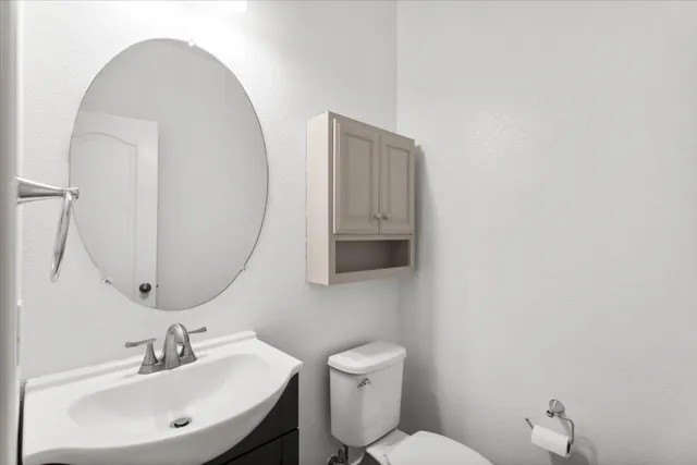 a bathroom with a toilet a sink and mirror