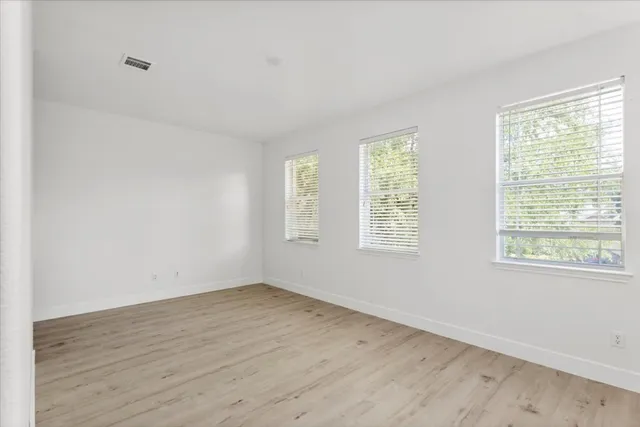 a view of a room with wooden floor and windows in it
